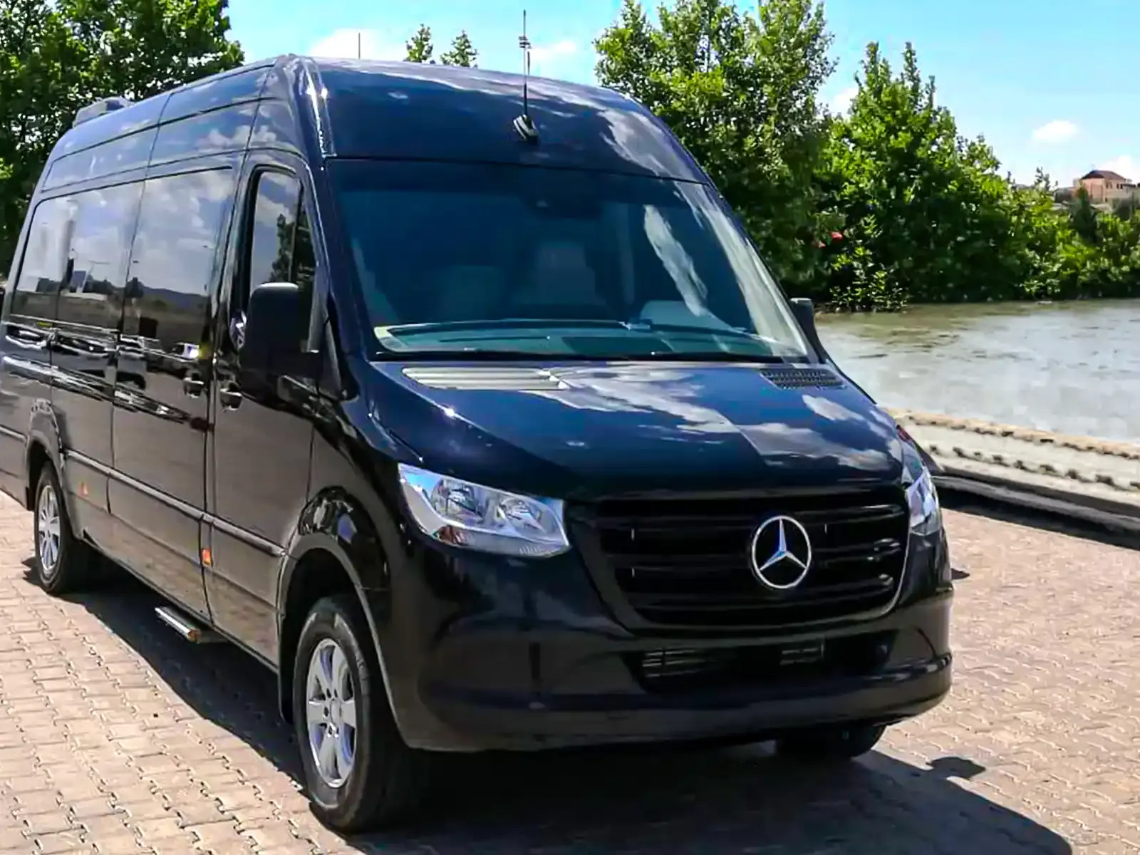 Black custom-body VIP Sprinter with chrome front grille parked on Cappadocia plains at golden hour