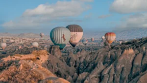 Hot air balloons over fairy chimneys at dawn, featured in our Cappadocia hot air balloon cancellation and weather guide.