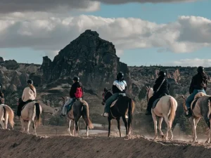 Cappadocia horse riding tour - People are riding horses in the valley.