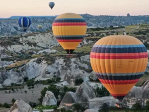 Hot air balloons rising over the fairy chimneys of Göreme, Cappadocia at sunrise