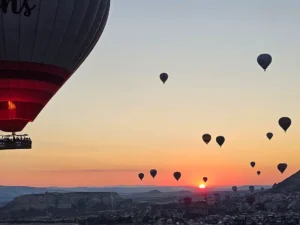 Hot air balloons flying over Çavuşin, Cappadocia at sunrise