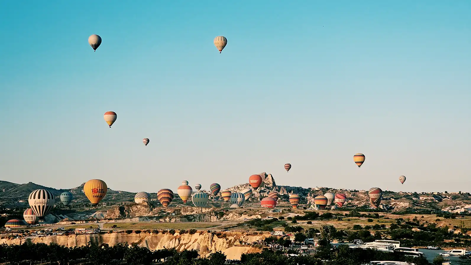 Hot air balloons floating over the landscape of Göreme, Cappadocia at sunrise, captured for Epic Turkey Travel.