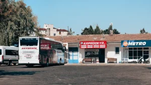 Bus company ticket desks side by side at a Turkish otogar, with an intercity coach parked outside