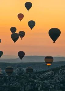 Hot air balloons launching at sunrise near Göreme after a pre-dawn hotel pickup